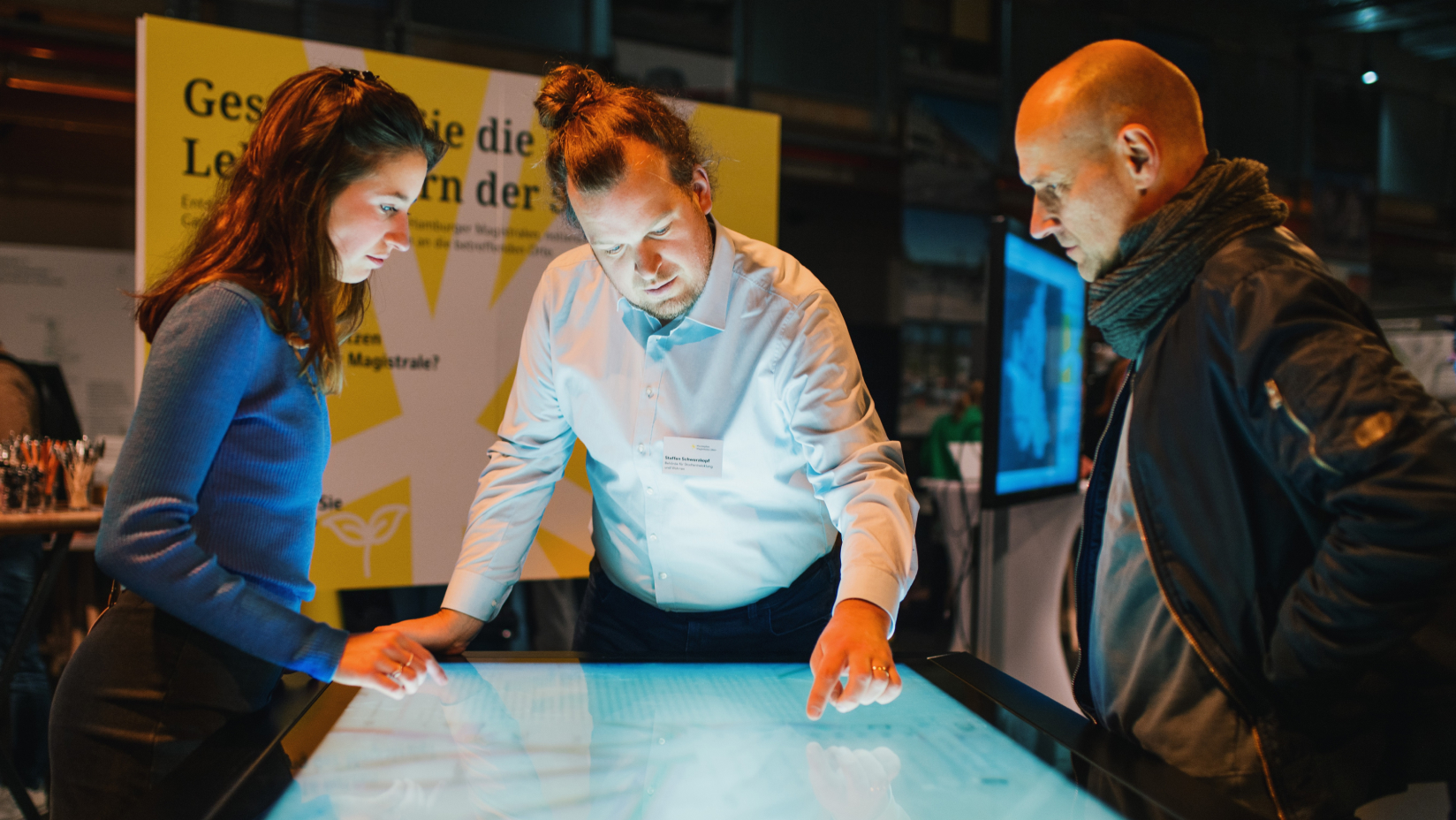 Three persons around the touchtable