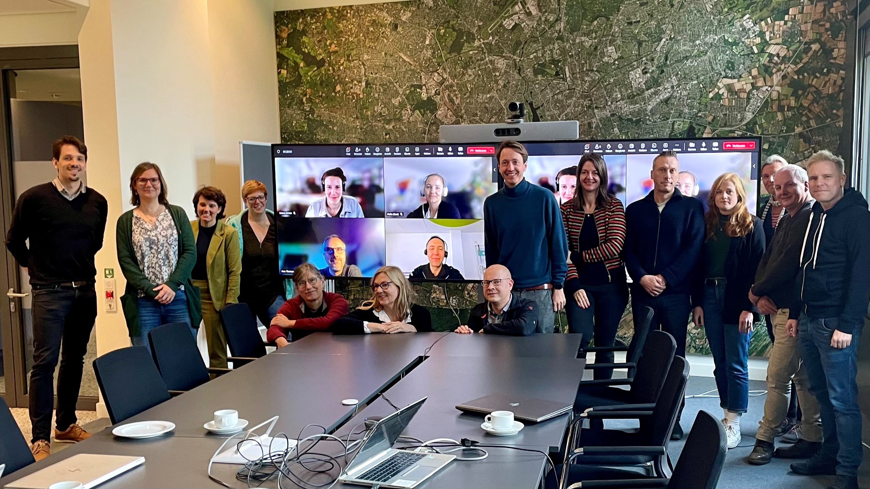 Gruppe Menschen vor Bildschirm mit Videokonferenz