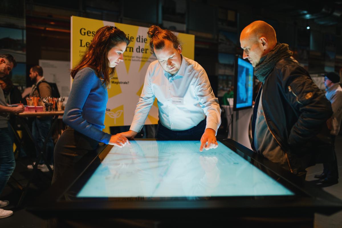 Drei Personen an einem Touchtable